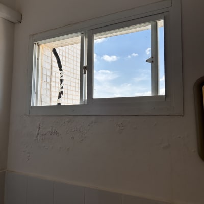 חלון עם קיר מתקלף ותקרה כחולה