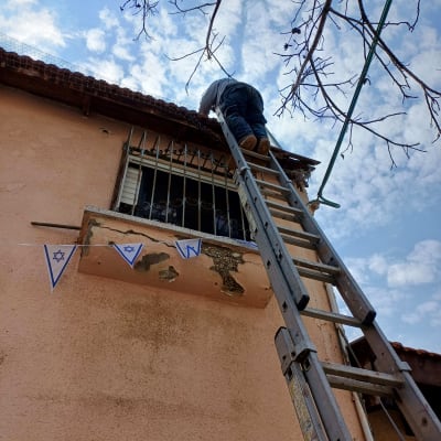 אדם על סולם מתקן גג רעפים