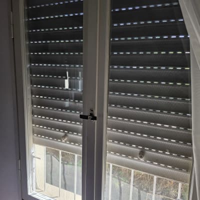 חלון עם תריסים סגורים ואור שמש