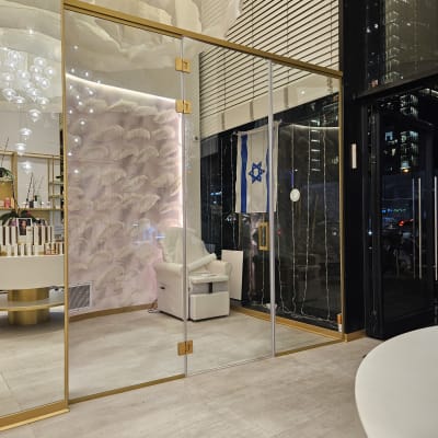 דלת זכוכית עם מסגרת זהב בחלל פנימי מואר