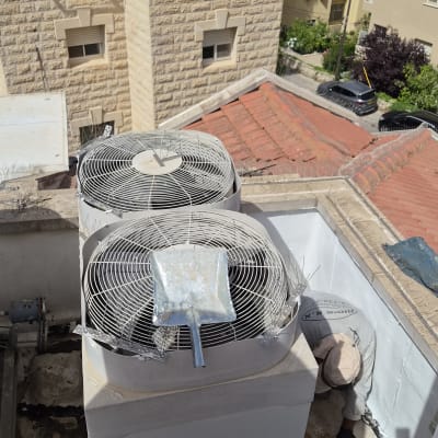 מערכת מיזוג אוויר על גג עם אדם עובד