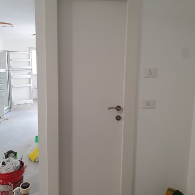 דלת לבנה עם ידית מתכת בחדר