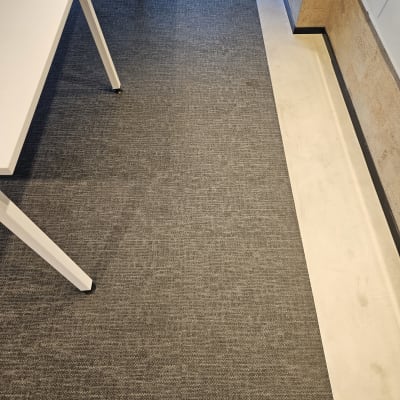 שטיח אפור על רצפה ליד שולחן לבן