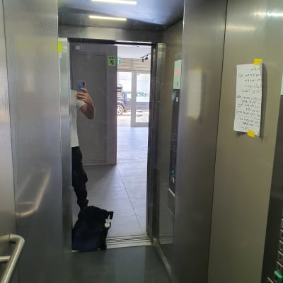 מראה זכוכית במעלית עם השתקפות אדם