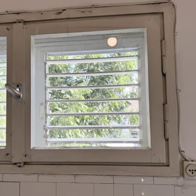 חלון עם תריסים מזכוכית ועץ