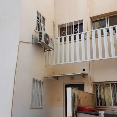 חלונות עם סורגים לבנים על קיר חיצוני