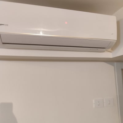 מזגן קיר לבן עם נורית חיווי אדומה