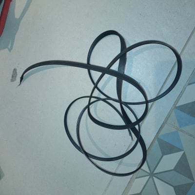 חגורת גומי שחורה מונחת על רצפה אפורה