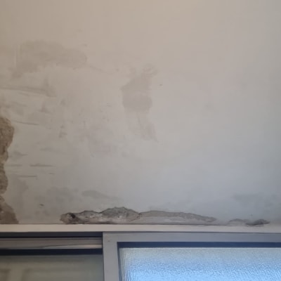 תיקון קיר עם סדקים ותיקונים ליד חלון