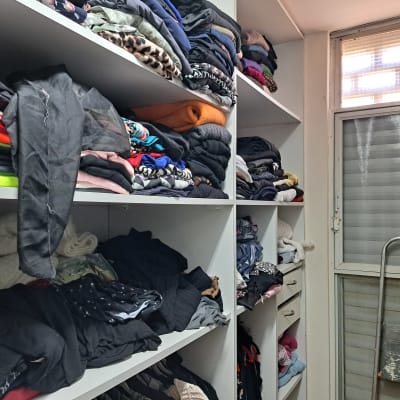 בגדים מקופלים בארון מדפים בחדר מסודר