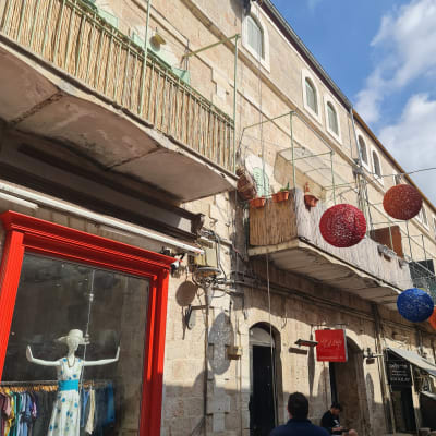 אדם מטפס על קיר בניין עם ציוד טיפוס