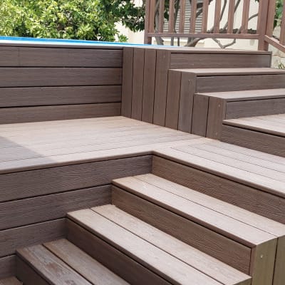 דק עץ חום עם מדרגות ובריכה קטנה