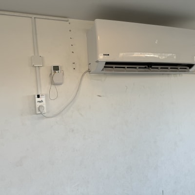 מזגן מותקן על קיר עם חוטי חשמל גלויים