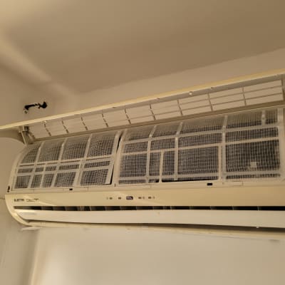 מזגן עם מכסה פתוח ורשתות מסנן נראות