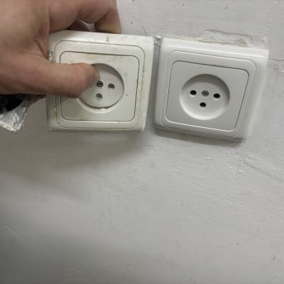 שקעי חשמל על קיר עם יד מתקינה