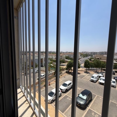 נוף עירוני מבעד לסורגים במרפסת