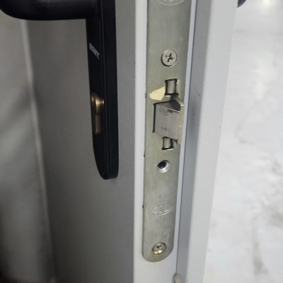 מנעול דלת מתכת עם ידית שחורה ובריח כסוף