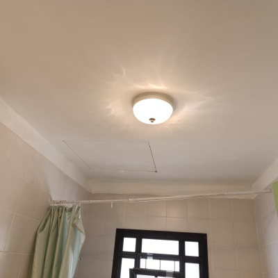 תקרה צבועה בלבן עם מנורה עגולה