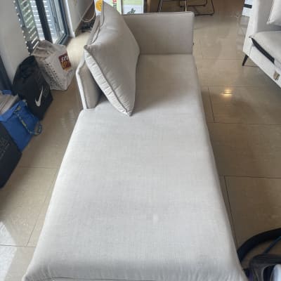 ספה בהירה עם כריות על רצפה מבריקה