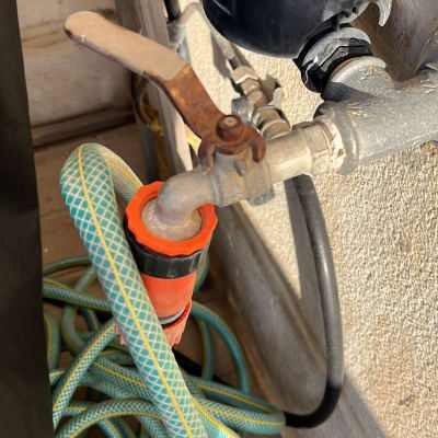 ברז מים עם צינור ירוק מחובר