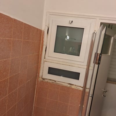 חלון אלומיניום בחדר אמבטיה עם אריחים כתומים