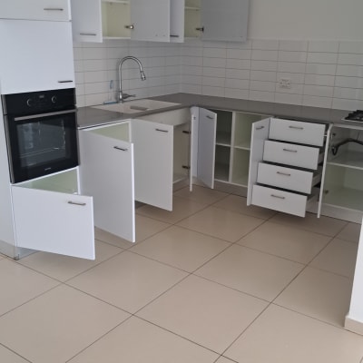 מטבח מבריק ונקי עם ארונות ומגירות פתוחים לאחר ניקיון יסודי