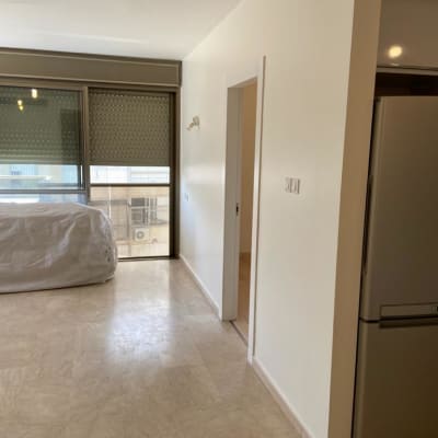 קיר צבוע בלבן עם חלון גדול ותריסים