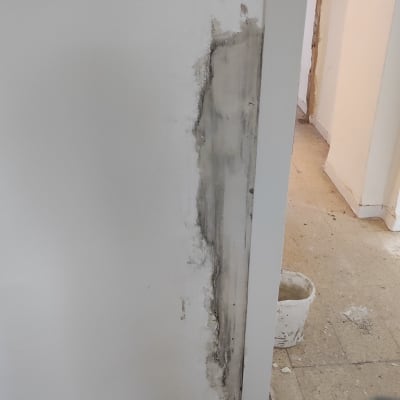 קיר עם תיקון טיח, דלי על הרצפה