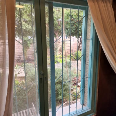 חלון זכוכית עם סורגים וגינה בחוץ