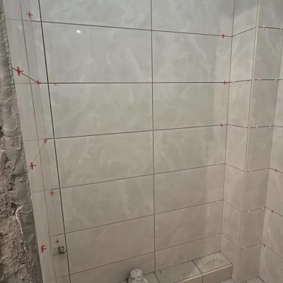 אריחי קרמיקה מותקנים על קיר עם סימני מדידה