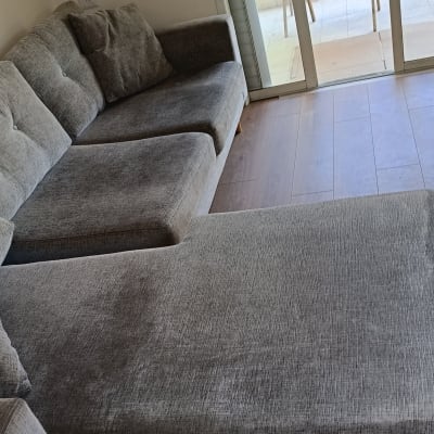 ספה אפורה ליד חלון עם נוף ירוק