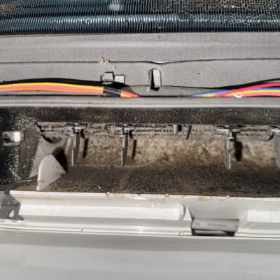 חלק פנימי של מזגן עמוס באבק ועובש לפני ניקוי