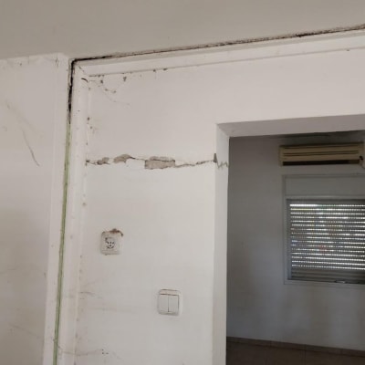 קיר עם סדקים ותיקונים, שקע חשמל ומתג