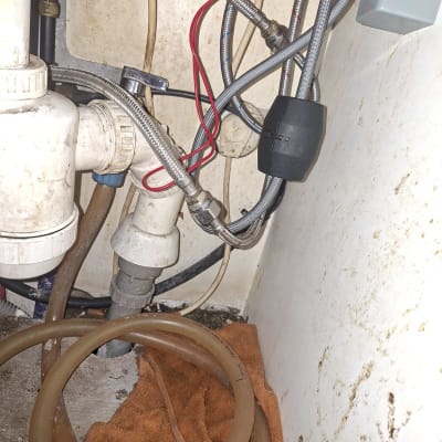 צנרת מתחת לכיור עם חיבורים וצינורות