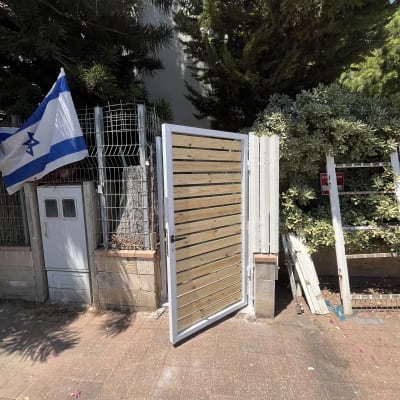 שער עץ פתוח עם מסגרת מתכת לבנה