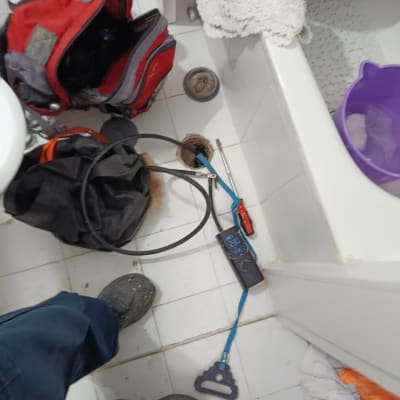 כלי עבודה וצינור בחדר אמבטיה, תיק פתוח על הרצפה