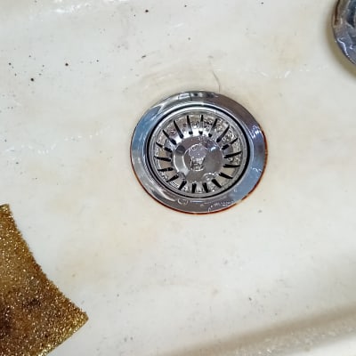 כיור עם מסננת נירוסטה ומטליות ניקוי