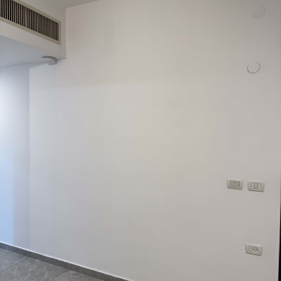 קיר צבוע עם שקעי חשמל ומתגים