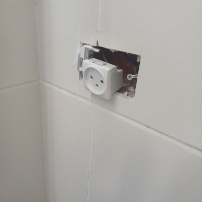 שקע חשמלי מותקן בקיר עם חוטים חשופים