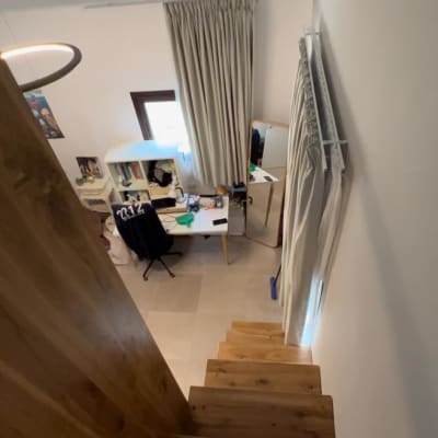 מדרגות עץ מובילות לחדר עם שולחן עבודה