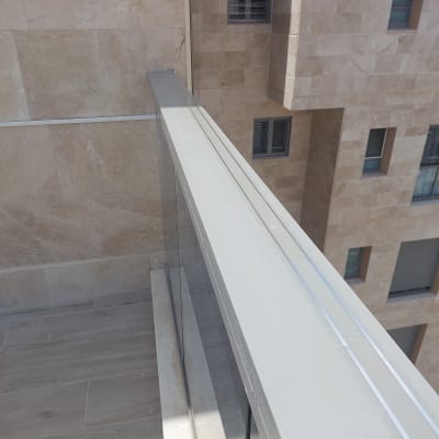 מעקה זכוכית עם מסגרת מתכת במרפסת