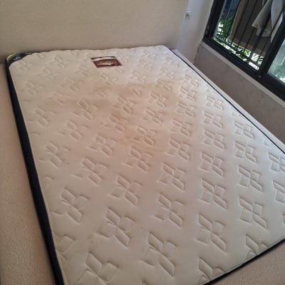 מזרן על מיטה עם כתמים, ליד חלון