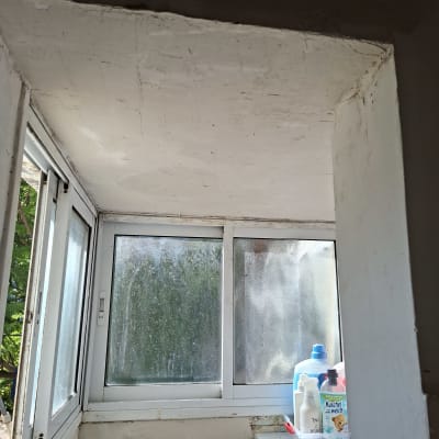 חלון עם מוצרי ניקוי על מדף לידו