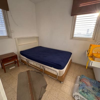 חדר עם מיטה, שידה ושקית מתנה צהובה