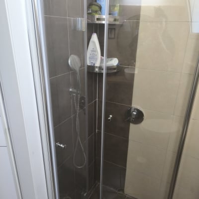 מקלחון עם מדפים ומוצרי טיפוח