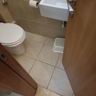 חדר שירותים עם כיור קטן ונייר טואלט