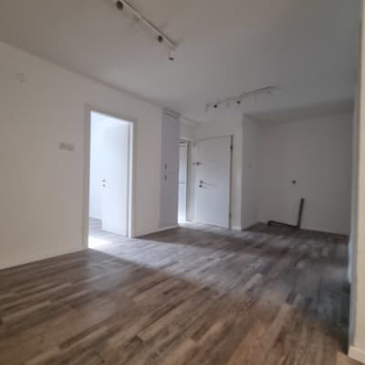 חדר עם רצפת עץ חדשה ותאורת מסילה