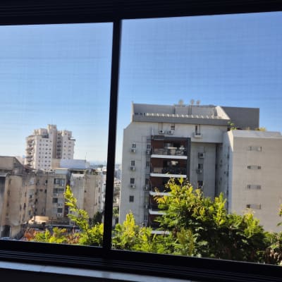 חלון אלומיניום עם נוף עירוני ברקע