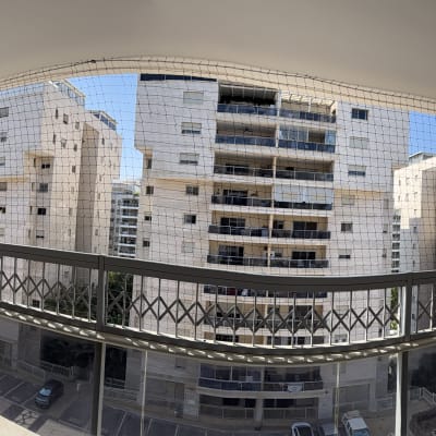 מרפסת עם רשת נגד יונים בבניין מגורים