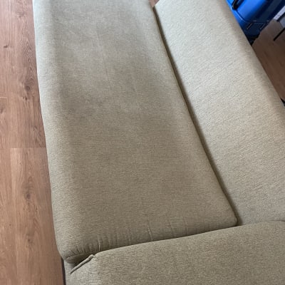 ספה ירוקה בחדר עם רצפת עץ